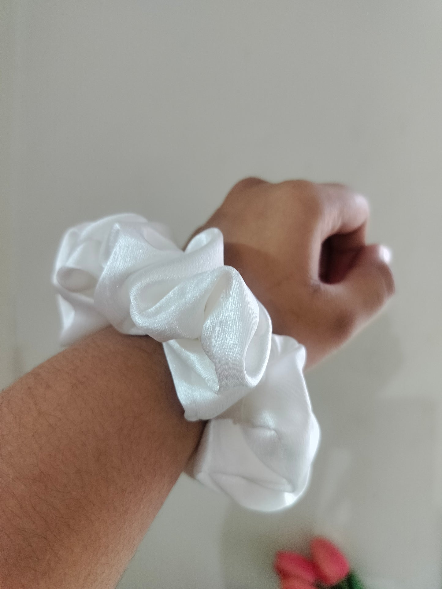 White soft silk scrunchie on a wrist