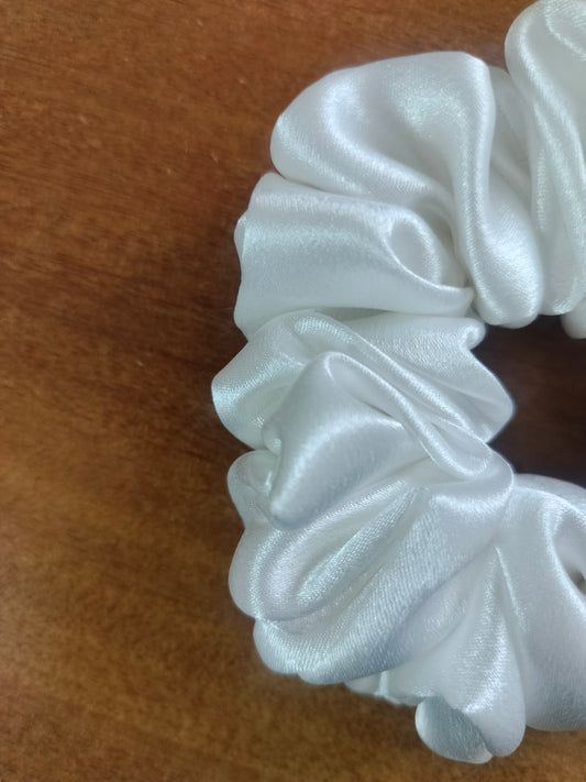 White silk scrunchie on a wooden surface